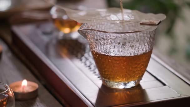 Verter té chino oolong en una taza de vidrio — Vídeo de stock