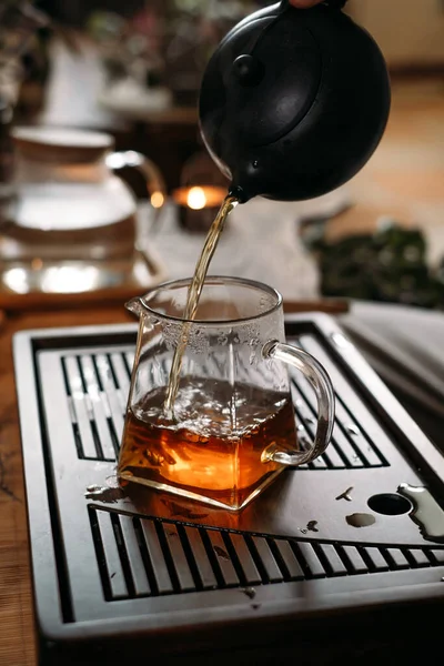 Традиционная чайная церемония - наливание китайского улуна в стеклянную чашку — стоковое фото