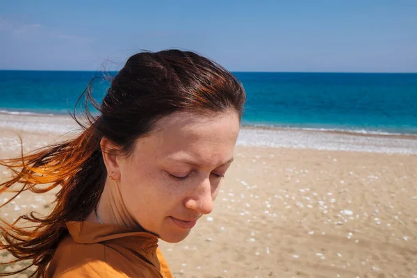 Одинокая женщина чувствует свободу и наслаждается природой у моря — стоковое фото