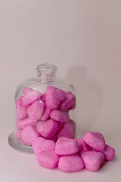 Glas Voller Rosafarbener Herzförmiger Bonbons Auf Rosa Hintergrund Haufen Bonbons lizenzfreie Stockbilder