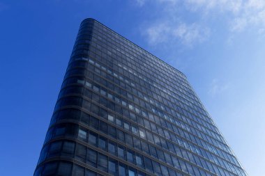 Yüksek ofis binası. Arkasında mavi gökyüzü olan bir gökdelen.