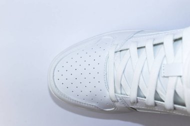 Beyaz arka planda beyaz bir spor ayakkabısının üst görüntüsü - beyaz bağcıklı beyaz ayakkabı