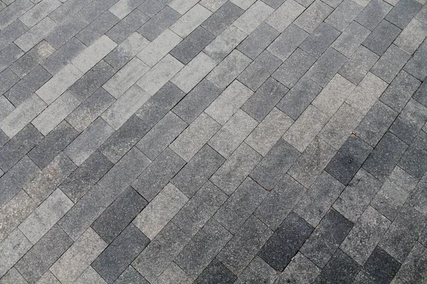 Yeşil bir çimenliğin arka planında asfalt döşeme