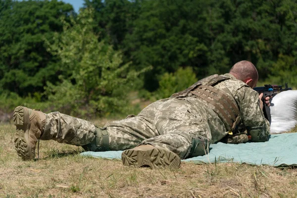 The Ukrainian military fires from a machine gun. Military man shoots from a machine gun in ukraine