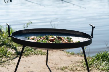 Sosis ve bitkilerle çırpılmış yumurtalar doğada kalın bir tavada. Kırsal, ev yapımı yemek..