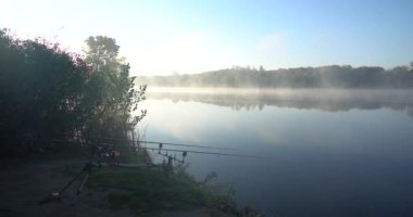 Parıldayan güneş ışığıyla gölde oltayla balık tutmak