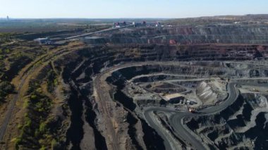 Taş ocağı maden ocağı kamyonları metalürjik üretim büyük çukur manzaralı insansız hava aracı.