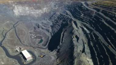Taş ocağı maden ocağı kamyonları metalürjik üretim büyük çukur manzaralı insansız hava aracı.