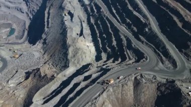 Taş ocağı maden ocağı kamyonları metalürjik üretim büyük çukur manzaralı insansız hava aracı.