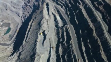 Taş ocağı maden ocağı kamyonları metalürjik üretim büyük çukur manzaralı insansız hava aracı.