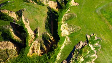 Kanyon uçurumları, yeşil çim manzaralı.