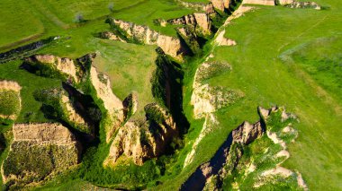 Kanyon uçurumları, yeşil çim manzaralı.