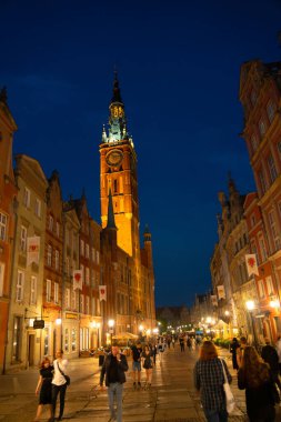 Scenic summer evening panorama of architectural pedestrians tourists people walk along the evening street of the Old Town GDANSK, POLAND - July 6, 2022