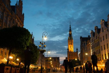 Scenic summer evening panorama of architectural pedestrians tourists people walk along the evening street of the Old Town GDANSK, POLAND - July 6, 2022
