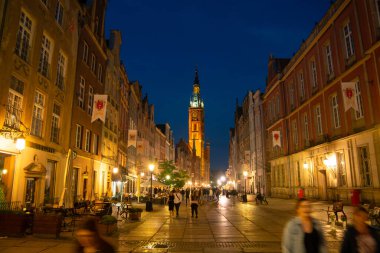 Scenic summer evening panorama of architectural pedestrians tourists people walk along the evening street of the Old Town GDANSK, POLAND - July 6, 2022