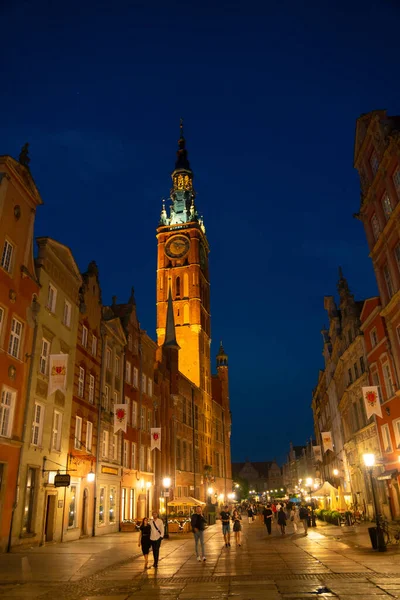 Scenic summer evening panorama of architectural pedestrians tourists people walk along the evening street of the Old Town GDANSK, POLAND - July 6, 2022