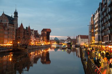 Scenic summer evening panorama of the architectural embankment of the Baltic port in the evening street of the Old Town GDANSK, POLAND - July 6, 2022