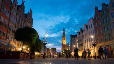 Scenic summer evening panorama of architectural pedestrians tourists people walk along the evening street of the Old Town GDANSK, POLAND - July 6, 2022