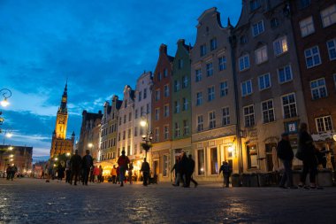 Scenic summer evening panorama of architectural pedestrians tourists people walk along the evening street of the Old Town GDANSK, POLAND - July 6, 2022