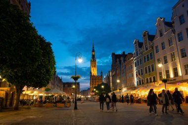Scenic summer evening panorama of architectural pedestrians tourists people walk along the evening street of the Old Town GDANSK, POLAND - July 6, 2022