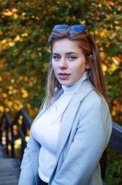 Sonbaharda mutlu genç bir kız sonbahar yapraklarının arka planında