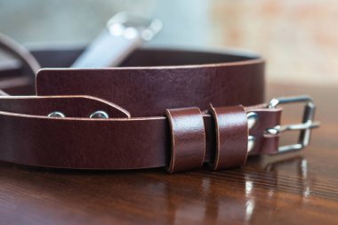 Ahşap arka planda şık deri kemer