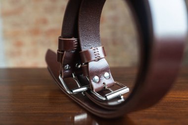 Eski ahşap arka planda erkek deri pantolon kemeri, el yapımı.