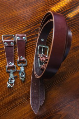 Erkek modası için ahşap arka planda el yapımı şık deri kemer.