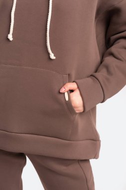 Beyaz arka planda gri eşofman giyen bir kız.