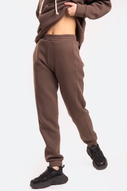 Beyaz arka plandaki bir kızın üzerinde gri pantolon