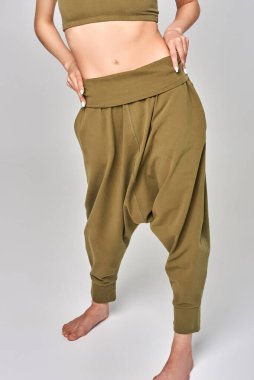 Genç bir kız elini belinde tutar.