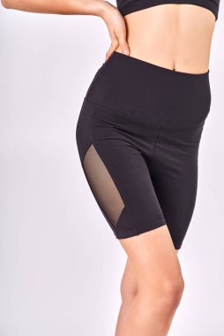 Beyaz bir arka planda siyah taytlı genç bir kız.