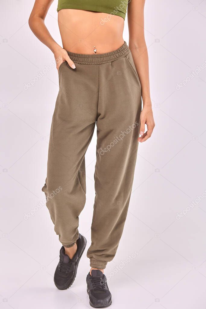 A young girl in grey sweatpants on a white background