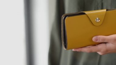 The girls hands hold a gray purse