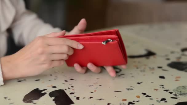 Mãos de uma jovem considera uma bolsa vermelha — Vídeo de Stock