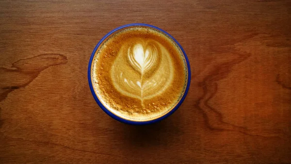 Uma Xícara Café Arte Latte Fundo Madeira — Fotografia de Stock