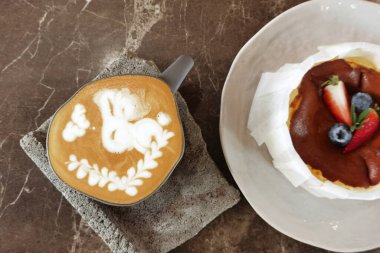 Bir fincan sütlü kahve, arka plan için de kek.                                            