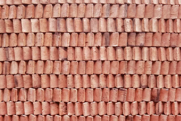 close up of wall clay stack of red clay bricks in rows for background