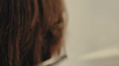 Berber dükkanında saç kesimi yapan genç adam. 