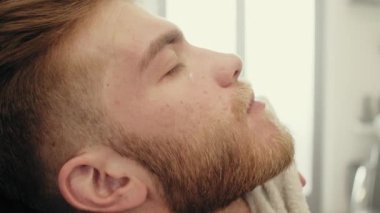 Berber dükkanındaki adam saç kesimi yapıyor. 