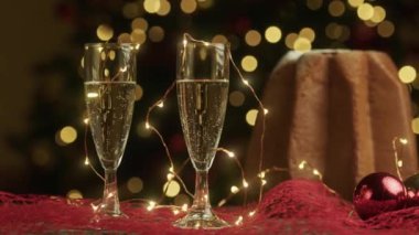 Arka planda yılbaşı ışıkları olan şampanya kadehleri, görüntüler 