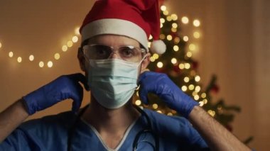 Doktor maskesini, koronavirüsünü ve noel konsepti videosunu çıkarıyor.