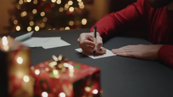 Partial view of man writing letter with festive christmas background footage — Stock Footage Partial View Man Writing Letter Festive Christmas Background Footage Video Clip