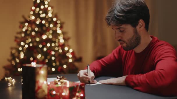 Young Man Writing Letter Festive Christmas Background Footage — Stock Video