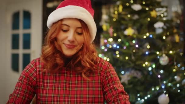 若い女性がクリスマスプレゼントを家に詰め込み — ストック動画