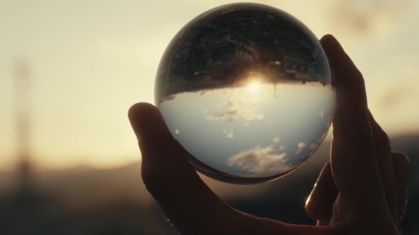 男人拿着有落日反射的玻璃球的镜头 — 图库视频影像