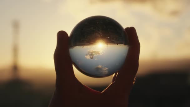 Footage Man Holding Glass Ball Sunset Sky Reflection — Stockvideo
