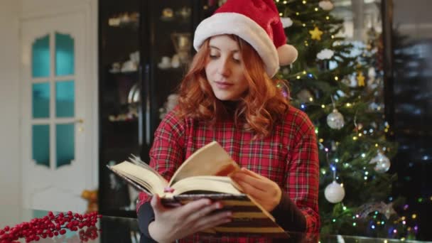 Joven Mujer Leyendo Libro Con Decoraciones Navidad Detrás Vídeo — Vídeo de stock