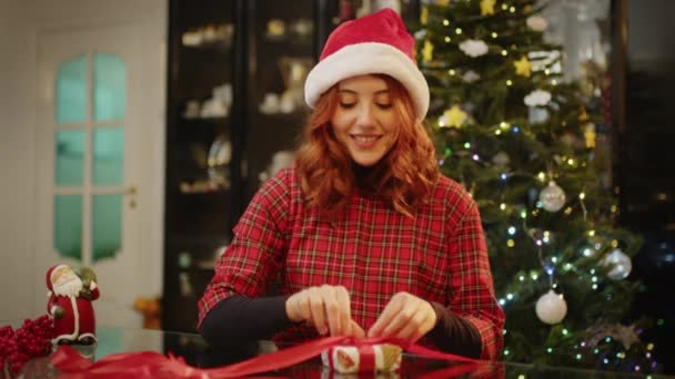Βίντεο Της Νεαρής Γυναίκας Συσκευασίας Χριστουγεννιάτικο Δώρο Στο Σπίτι — Αρχείο Βίντεο
