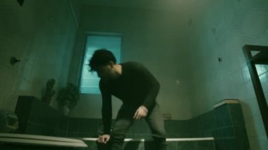 Young depressed boy seated on the bathtub